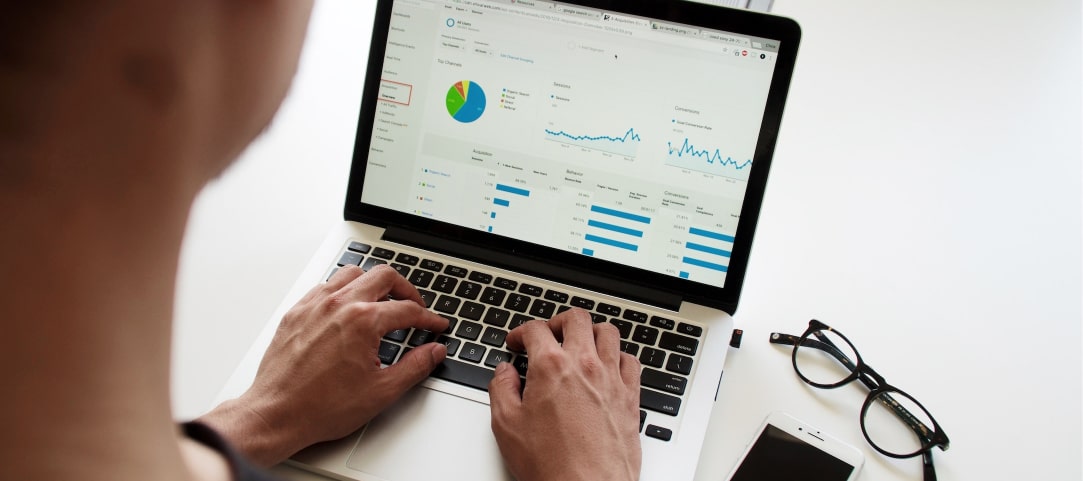Person typing on a computer that shows different graphs